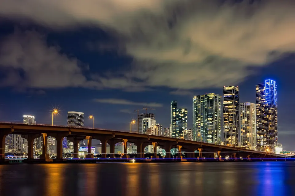Downtown Miami skyline and causeway bridge at night