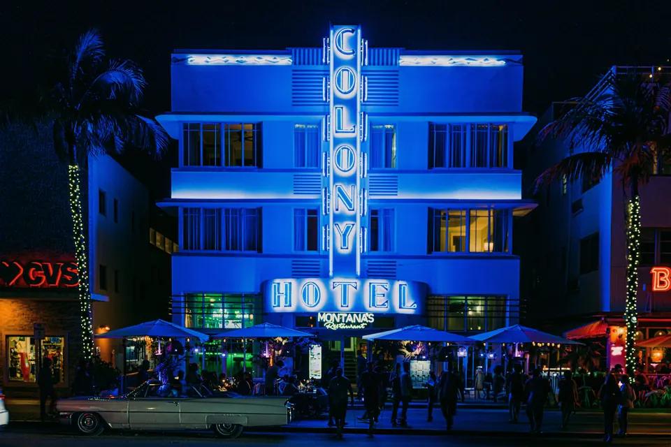 Neon sign of the Colony Hotel glowing on Ocean Drive at night