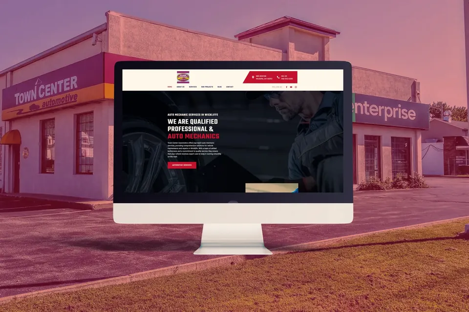 Auto repair shop website on a desktop monitor in front of the shop building