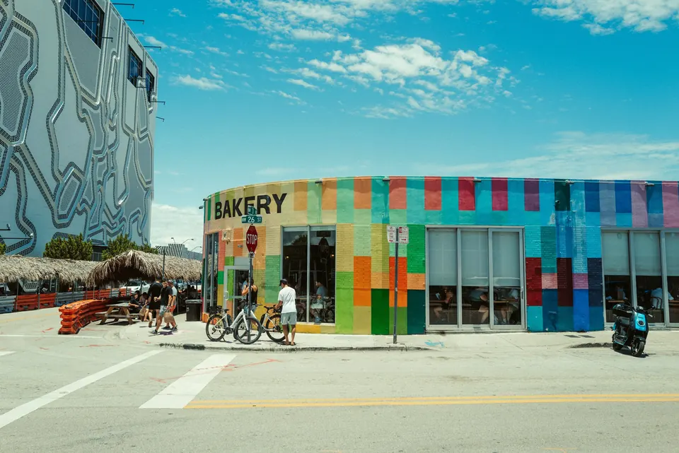 A bright mural covered storefront on a sunny street